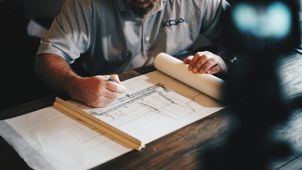 Professional reviewing a building plan at a desk